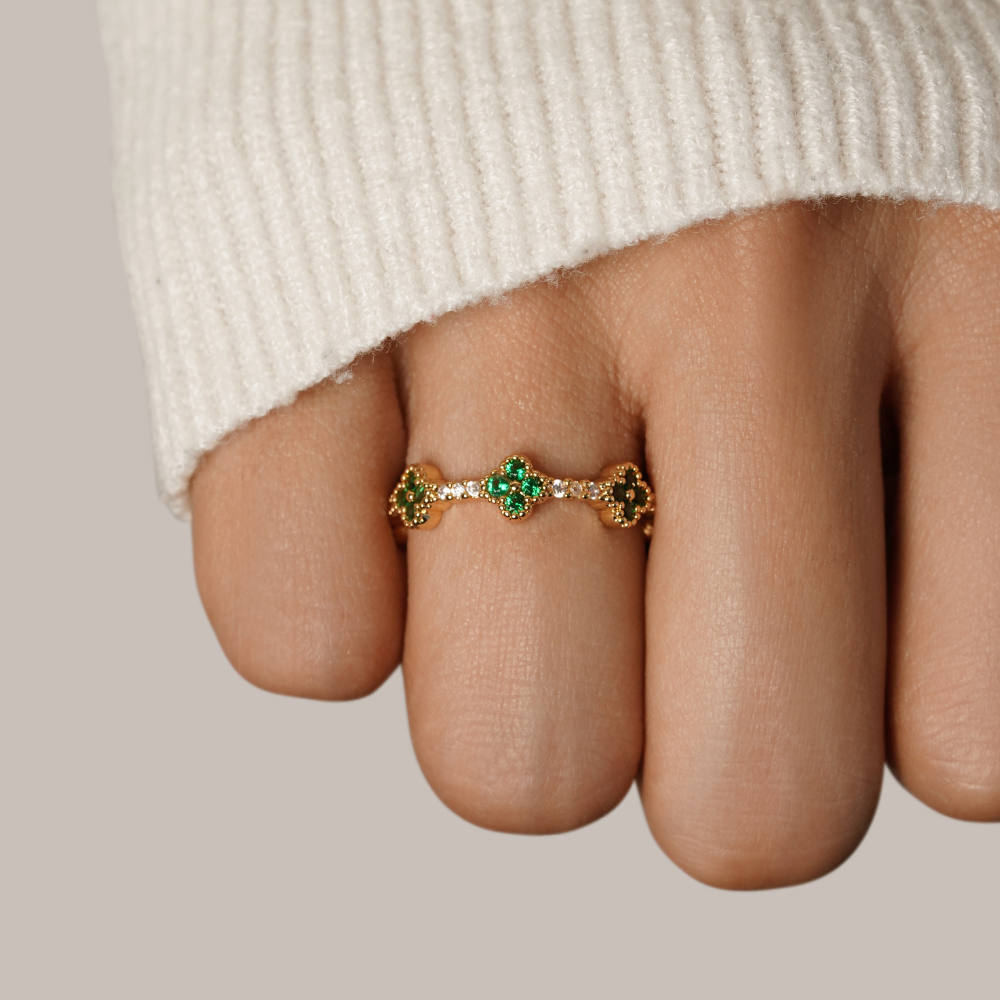 Annika – Anello placcato oro con dettagli floreali e un elemento in smeraldo.